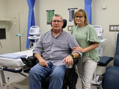 A man in a wheelchair with a woman standing beside him